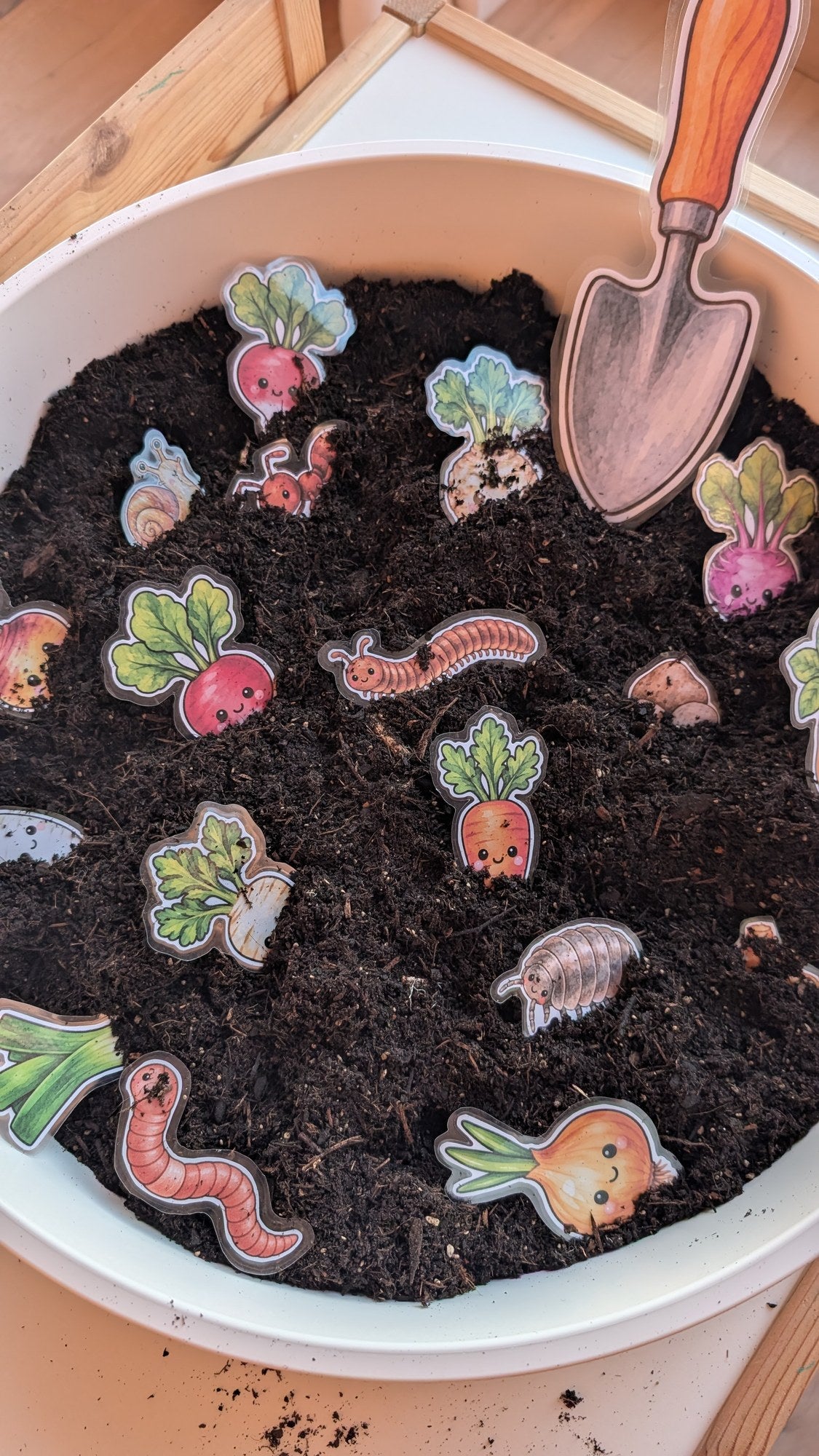 Sensory Play: Gemüse und Regenwurm in Erde mit kleiner Schaufel