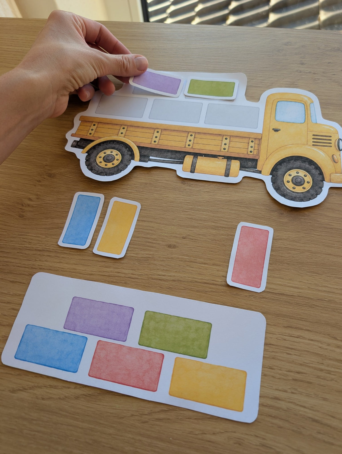 Child placing coloured building blocks on the construction truck